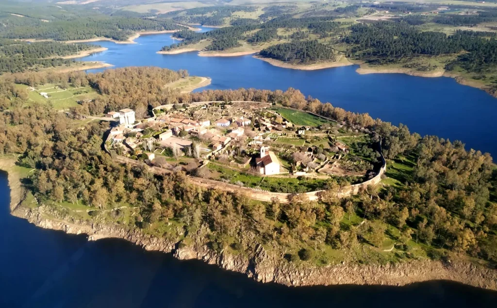El pueblo de Granadilla (situado en la provincia de Cáceres, España) es una antigua villa amurallada de origen árabe que fue expropiada y desalojada por el Estado en 1960. Los últimos habitantes se marcharon definitivamente en 1964. www.miteco.gob.es
 +3
El desalojo ocurrió debido a la construcción del embalse de Gabriel y Galán. El pueblo fue catalogado como zona inundable y sus rutas de acceso quedaron cortadas por el agua, lo que obligó a sus residentes a abandonarlo y trasladarse a otros municipios. Paradójicamente, un error de cálculo evitó la tragedia: las aguas nunca llegaron a inundar el pueblo. Granadilla se quedó sin sus habitantes, pero resistió intacta sobre una colina rodeada por el pantano. 

www.miteco.gob.es
 +4
Actualmente, Granadilla es un museo al aire libre y no ha caído en el olvido: 

Facebook
·Rutas por Extremadura
 +3
Protección y restauración: En 1980 fue declarada Conjunto Histórico-Artístico. 

Instagram
·ExtremaduraTips
Programa educativo: Desde 1984, forma parte del Programa de Recuperación de Pueblos Abandonados. Sirve como centro donde estudiantes y voluntarios participan en tareas de restauración durante el verano. 

Viajes National Geographic
 +1
Turismo: El pueblo está abierto al público, quienes pueden visitar su castillo medieval del siglo XV, recorrer las murallas y pasear por sus calles. 

YouTube
·Marcos que no Polo
 +2
Para conocer más sobre la historia, el encanto de sus calles y el ambiente de este rincón detenido en el tiempo:
Miniatura de vídeo relacionado
3m
🟢 Descubre GRANADILLA: El Pueblo Amurallado de España | Guía de Viaje

Marcos que no Polo
YouTube · 8 may 2025
Pueblo de Granadilla: Historia
La construcción del embalse de Gabriel y Galán conllevó la expropiación de casi todo el término municipal, incluido el casco urban...

www.miteco.gob.es

3m
🟢 Descubre GRANADILLA: El Pueblo Amurallado de España | Guía de Viaje

YouTube·Marcos que no Polo

1:25
Granadilla — el pueblo detenido En Granadilla ocurre algo muy extraño ...

Facebook·Rutas por Extremadura

0:35
📍Granadilla, en el norte de la provincia de Cáceres, es el pueblo que ...

Instagram·ExtremaduraTips
Breve historia de Granadilla - Turismo Ambroz-Cáparra
Granadilla es un pueblo medieval fundado por los musulmanes en torno al siglo IX como avanzadilla militar y defensiva. Tras varios...

turismoambrozcaparra.es
Qué ver en Granadilla, el pueblo fantasma que se convirtió en un ...
Qué ver en Granadilla, el pueblo fantasma que se convirtió en un imprescindible de Cáceres * Las calles han quedado en silencio, s...

Viajes National Geographic

19:39
Os enseño Granadilla, el pueblo abandonado por el embalse

YouTube·Nazaret Martín C.
En 1955, el Estado expropió y vació el pueblo cacereño de Granadilla ...
La localidad cacereña de Granadilla, en España, fué expropiada y desalojada por el Estado en 1960 por motivo de la construcción de...

Facebook

8m
GRANADILLA: the walled town that was left empty

YouTube·hispania magica

1:25
el pueblo detenido 🏰🌊🌿 En Granadilla ocurre algo muy extraño. 👉 Parece ...

Facebook·Rutas por Extremadura
INFORMACIÓN ℹ️ ⠀ Increíble aldea abandonada que te va enamorar, se llama: 🏘️📍 Granadilla Se encuentra en el norte de la provincia Cáceres. ⠀ 🏠Es una aldea muy interesante, porque esta ubicada en una península en el embalse de Gabriel y Galán. ⠀ ⛰️Además su entorno es mágico. Increíble parque natural, con aguas cristalinas con las vistas a la montañas. ⠀ ‼️Esta aldea no esta habitada, es mas como un museo por eso se puede visitar en un horario especial: ⠀ 🕢HORARIO: ⠀ ⚠️Lunes Cerrado ⠀ 🌸Abril -🍁Octubre: Mañanas 10 a 13:30 h, Tardes de 16 a 20 ⠀ 🎄Noviembre – ❄️Marzo: Mañanas 10 a 13:30 h, Tardes de 16 a 18 ⠀ La visita totalmente: GRATIS 🤑 ⠀ ✅Te puedo asegurar que es muy bonito y vale la pena visitarlo. ⠀ A pesar que es muy pequeño tiene sitios interesantes 👇🏻 ⠀ 1️⃣ Muralla 2️⃣ Castillo de Granadilla 3️⃣ PLAZA MAYOR 4️⃣ Antigua Cárcel y Cuartel de la Guardia Civil 5️⃣ Casa de Las Conchas ⠀ ¿Te gustaría visitar esta aldea? Sígueme para mas planes por España 🤗❤️🇪🇸
Este pueblo es una joya escondida ya que su belleza sigue intacta después de casi sesenta años que la han abandonado. Digamos que ...

Instagram
INFORMACIÓN ℹ️ ⠀ Increíble aldea abandonada que te va enamorar, se llama: 🏘️📍 Granadilla Se encuentra en el norte de la provincia Cáceres. ⠀ 🏠Es una aldea muy interesant | anastasia.viajera
Digamos que es un museo al aire libre, donde podrás caminar por sus calles empedradas y jugar con los animalitos que viven allí. L...

Facebook
Las respuestas de la IA pueden contener errores. Más información
